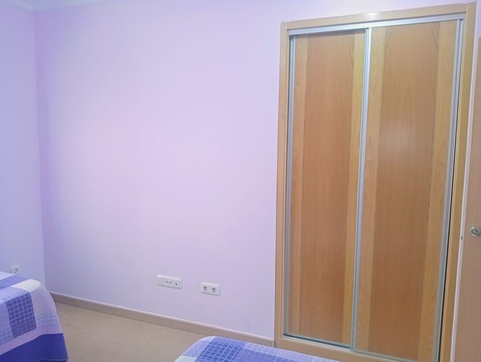 Una mesa y sillas en un balcón con un mantel azul.