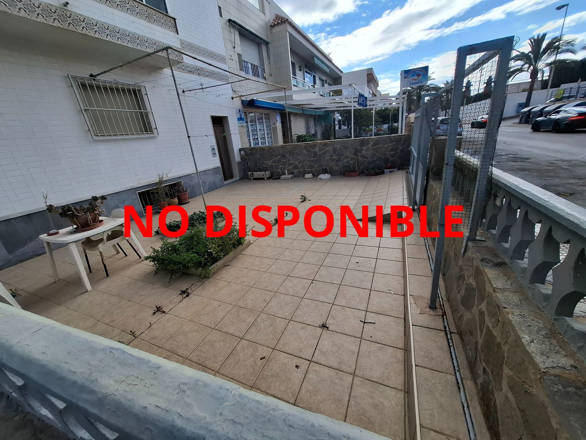 Un patio con una mesa y sillas frente a un edificio.