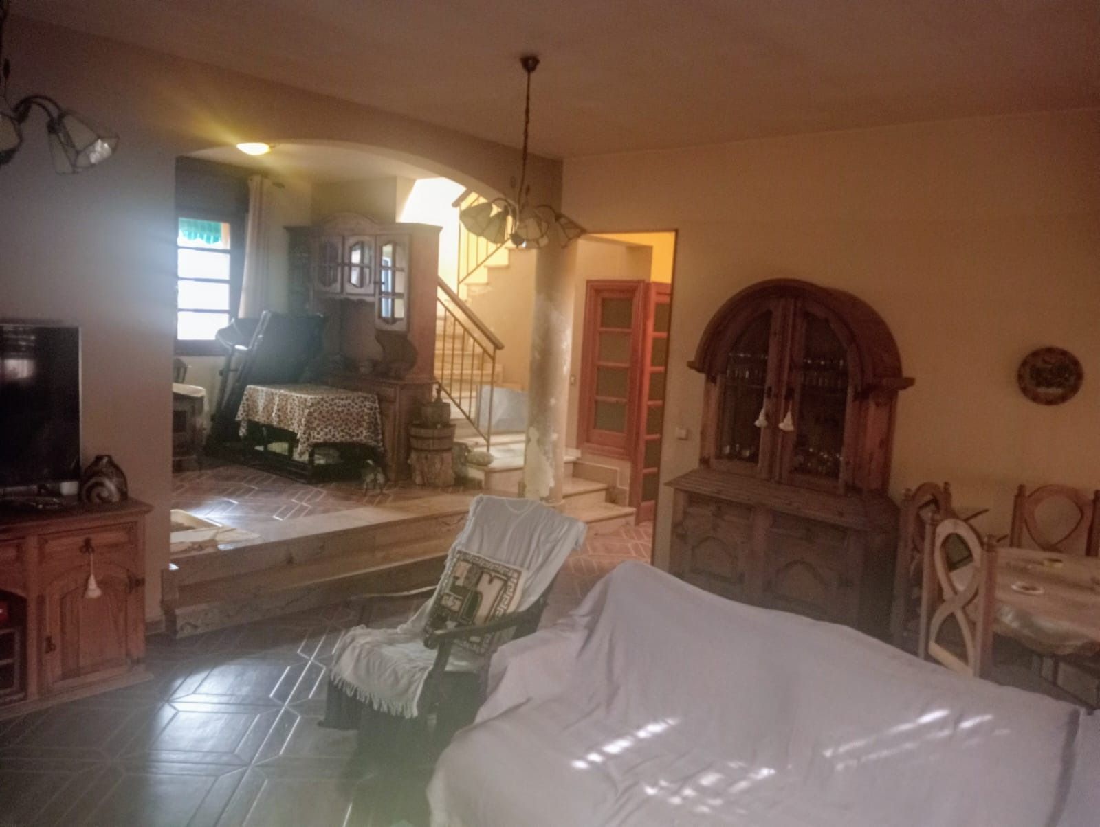 Una sala de estar con un sofá, una silla y escaleras.