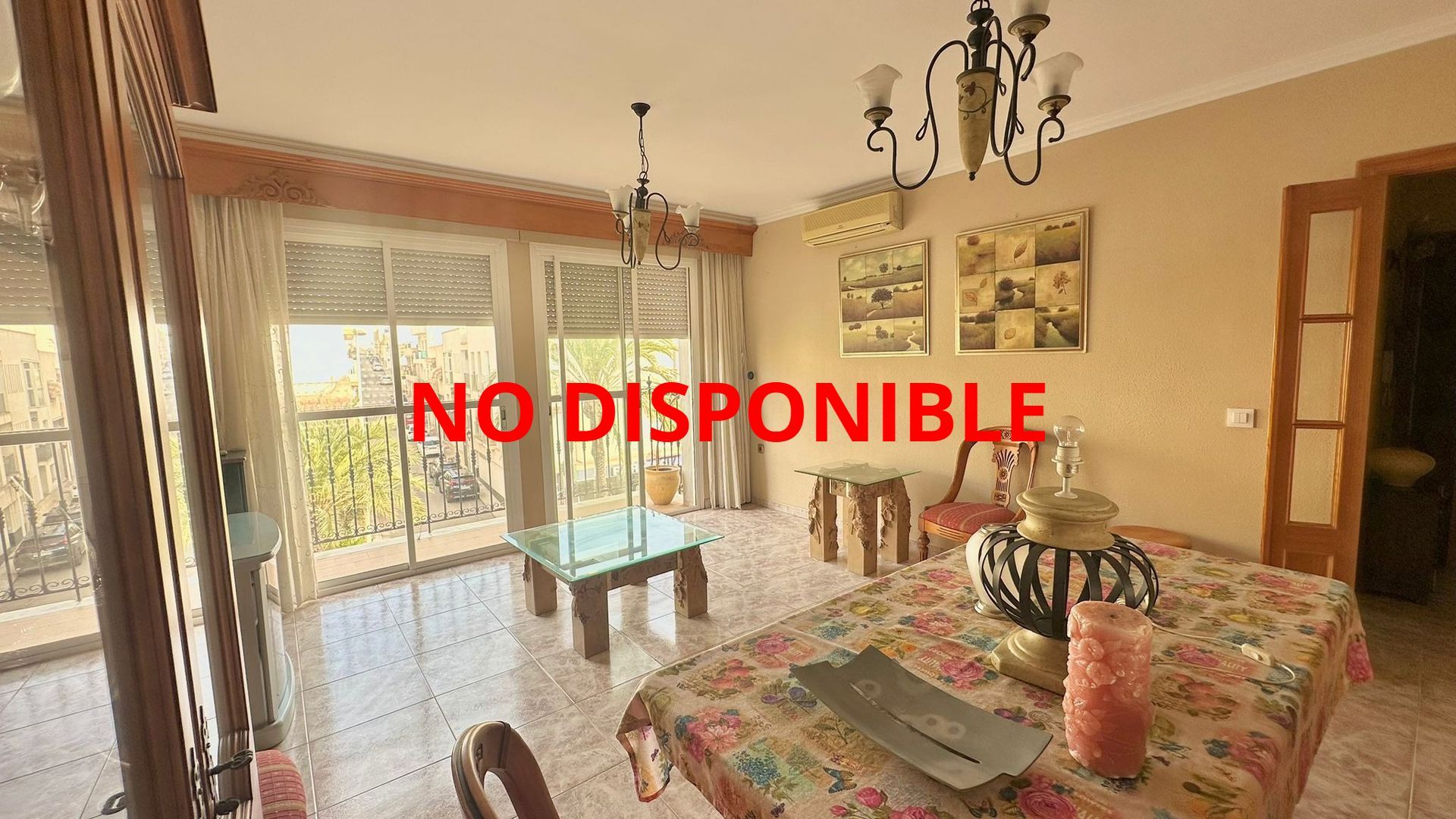 Una sala de estar con una mesa y sillas y una lámpara de araña.