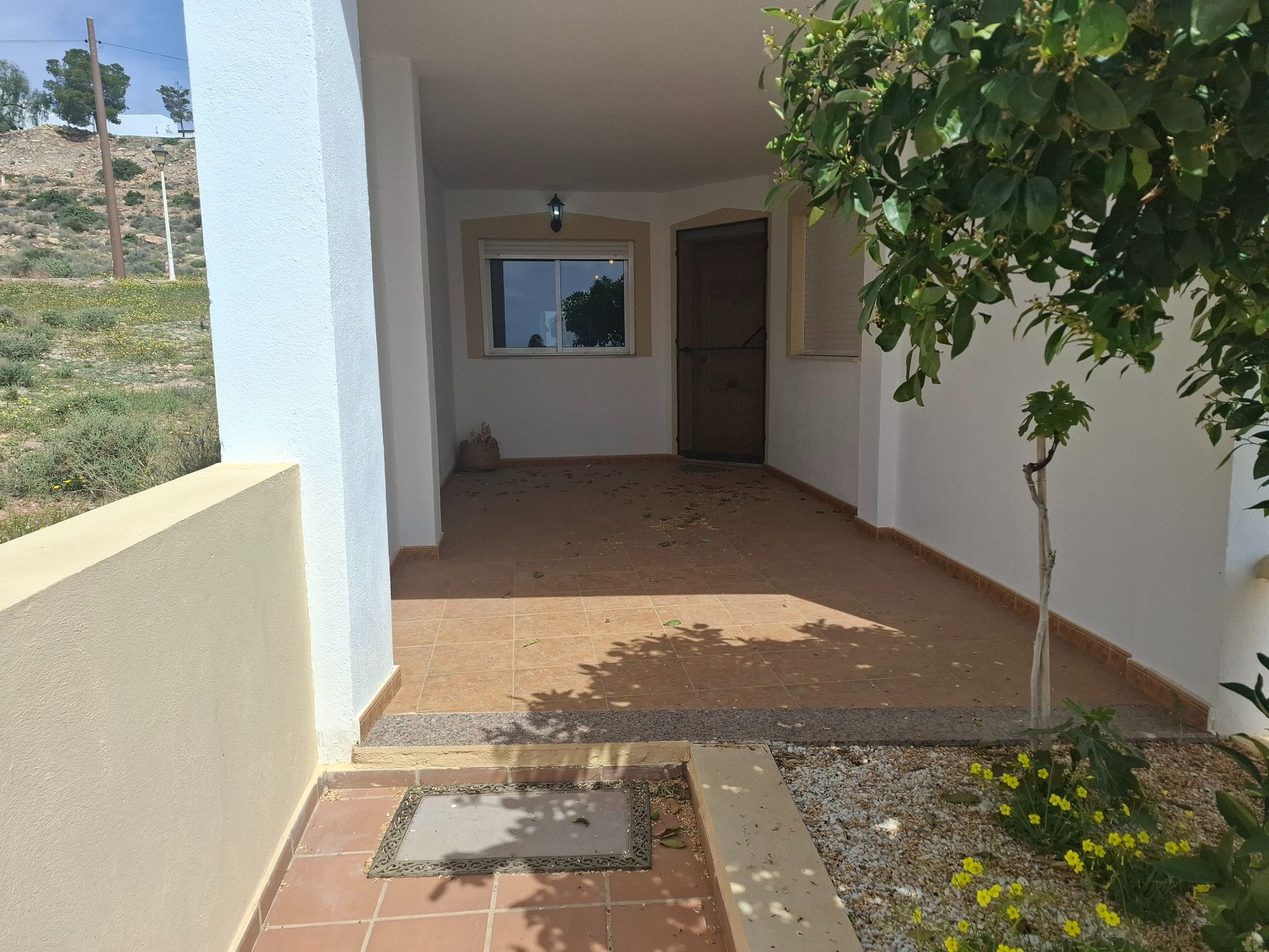 Una casa blanca con un árbol delante