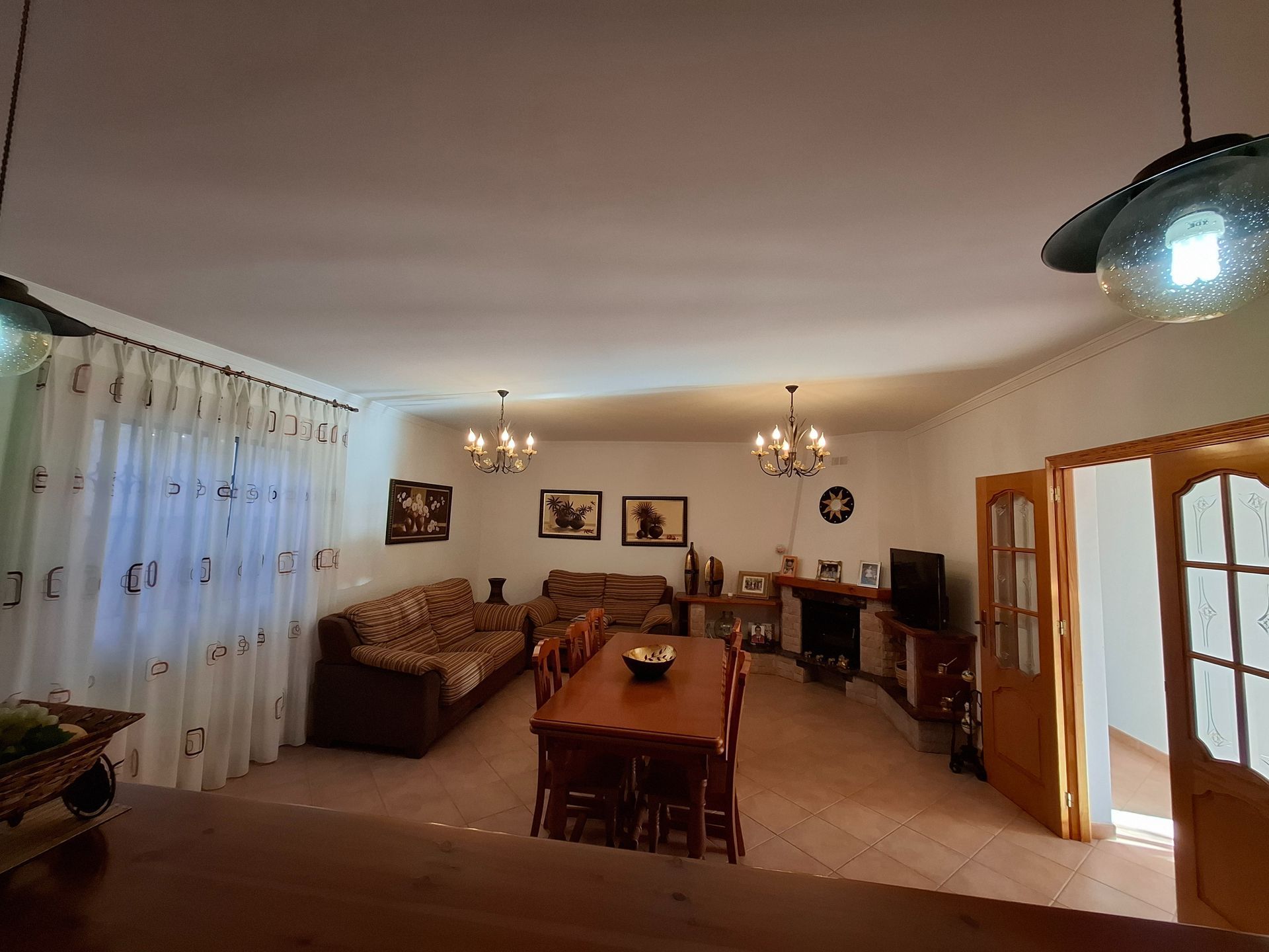 Una sala de estar con sofá, mesa, sillas y chimenea.