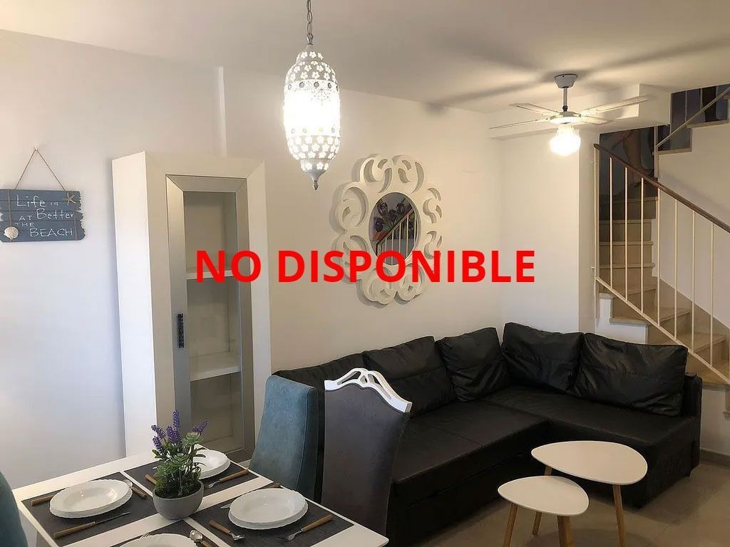 Una sala de estar con un sofá y una mesa y las palabras no disponible en la pared.