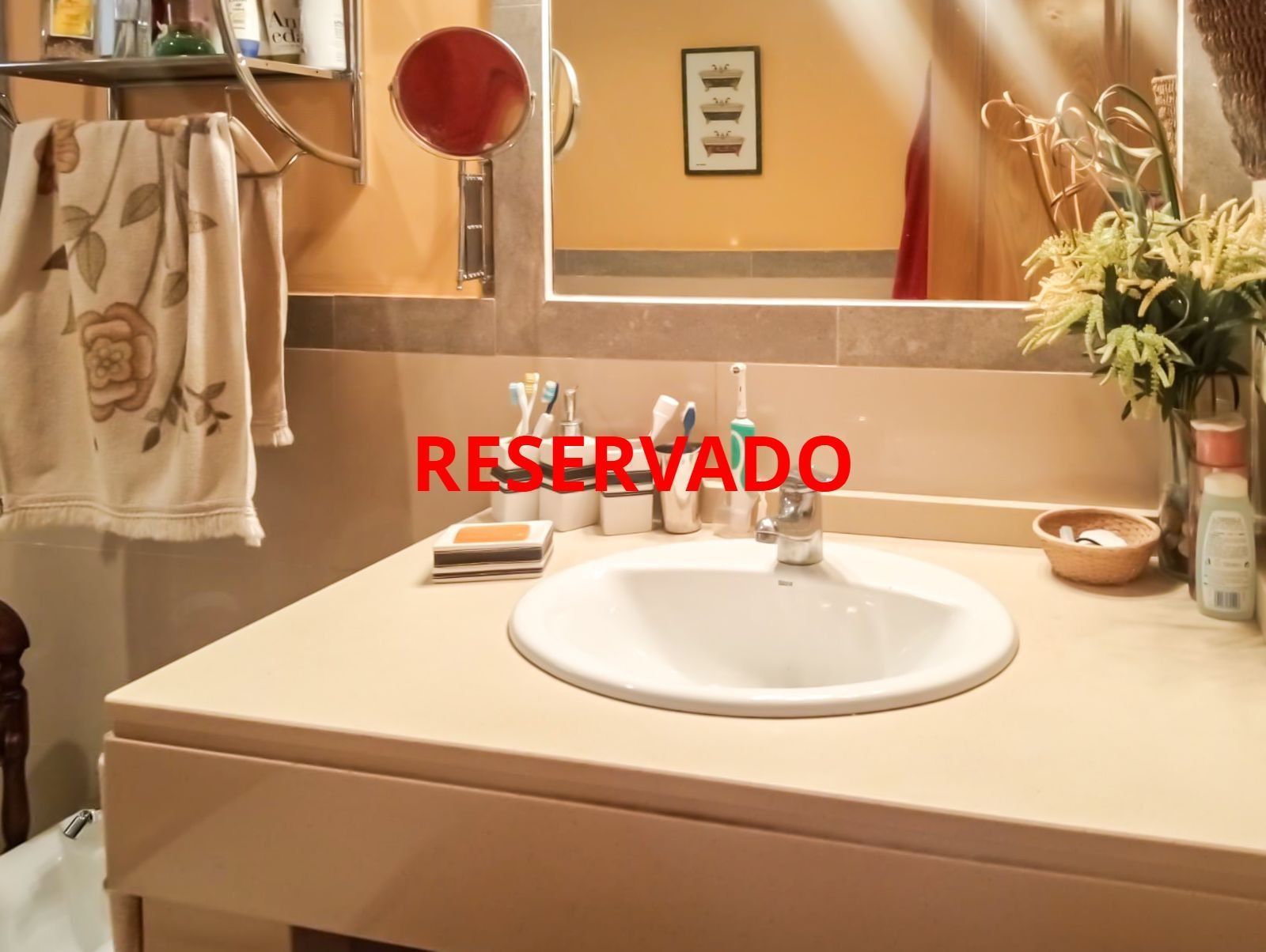 Un baño con lavabo y un cartel rojo que dice reservado