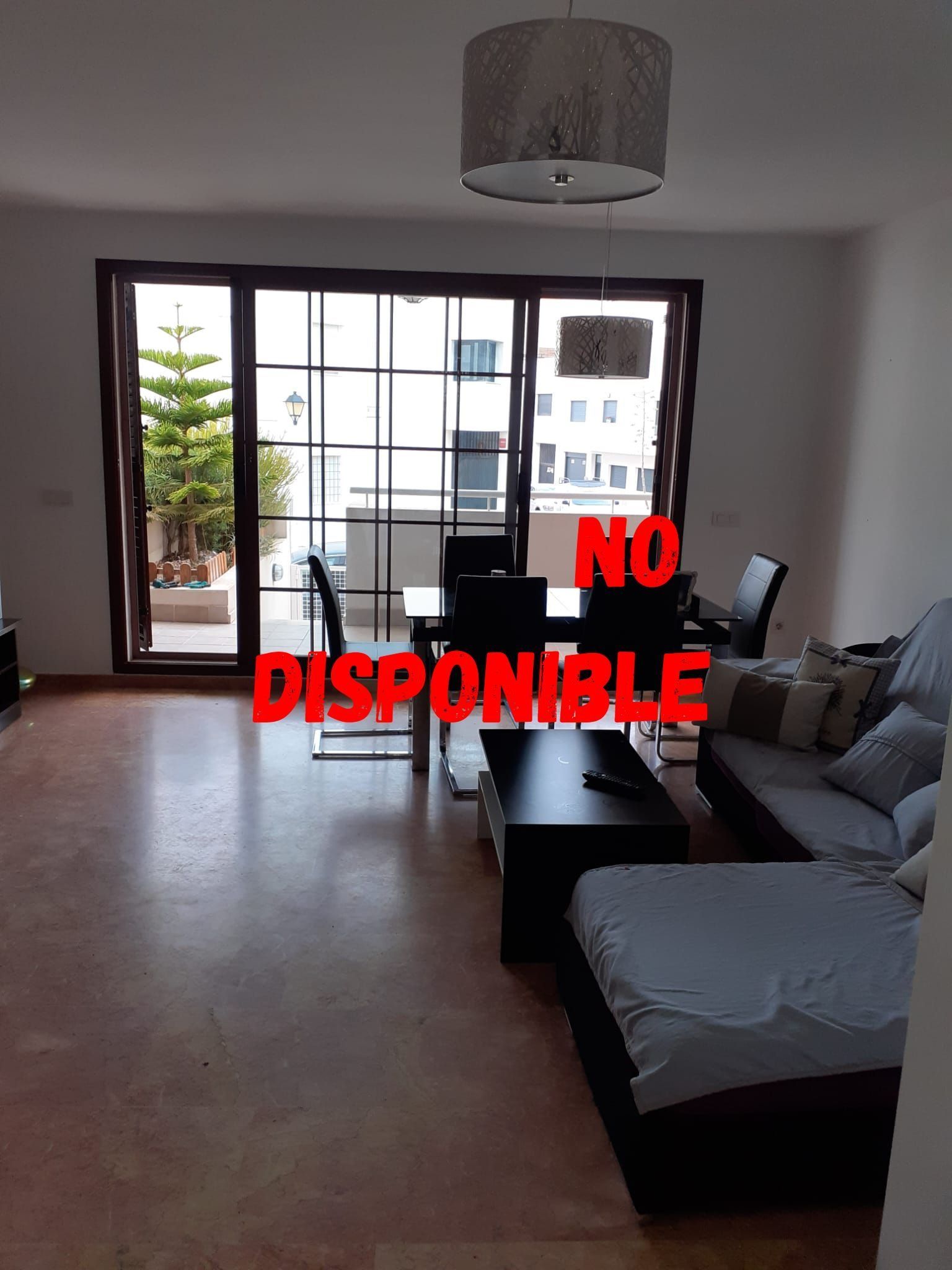 Una sala de estar con un sofá y una mesa y las palabras "no disponible" en la pared.