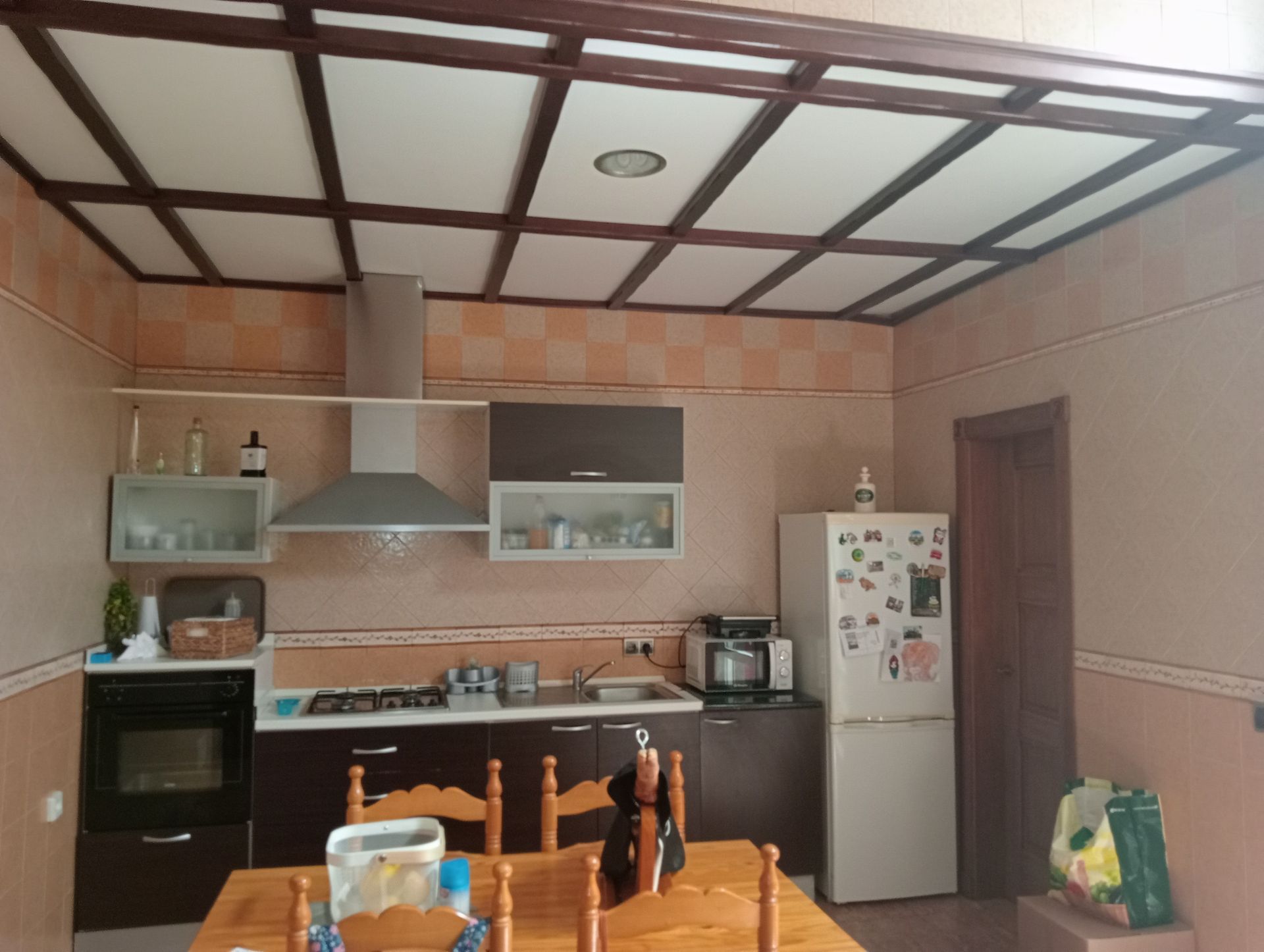 Una cocina con mesa y sillas y un refrigerador.