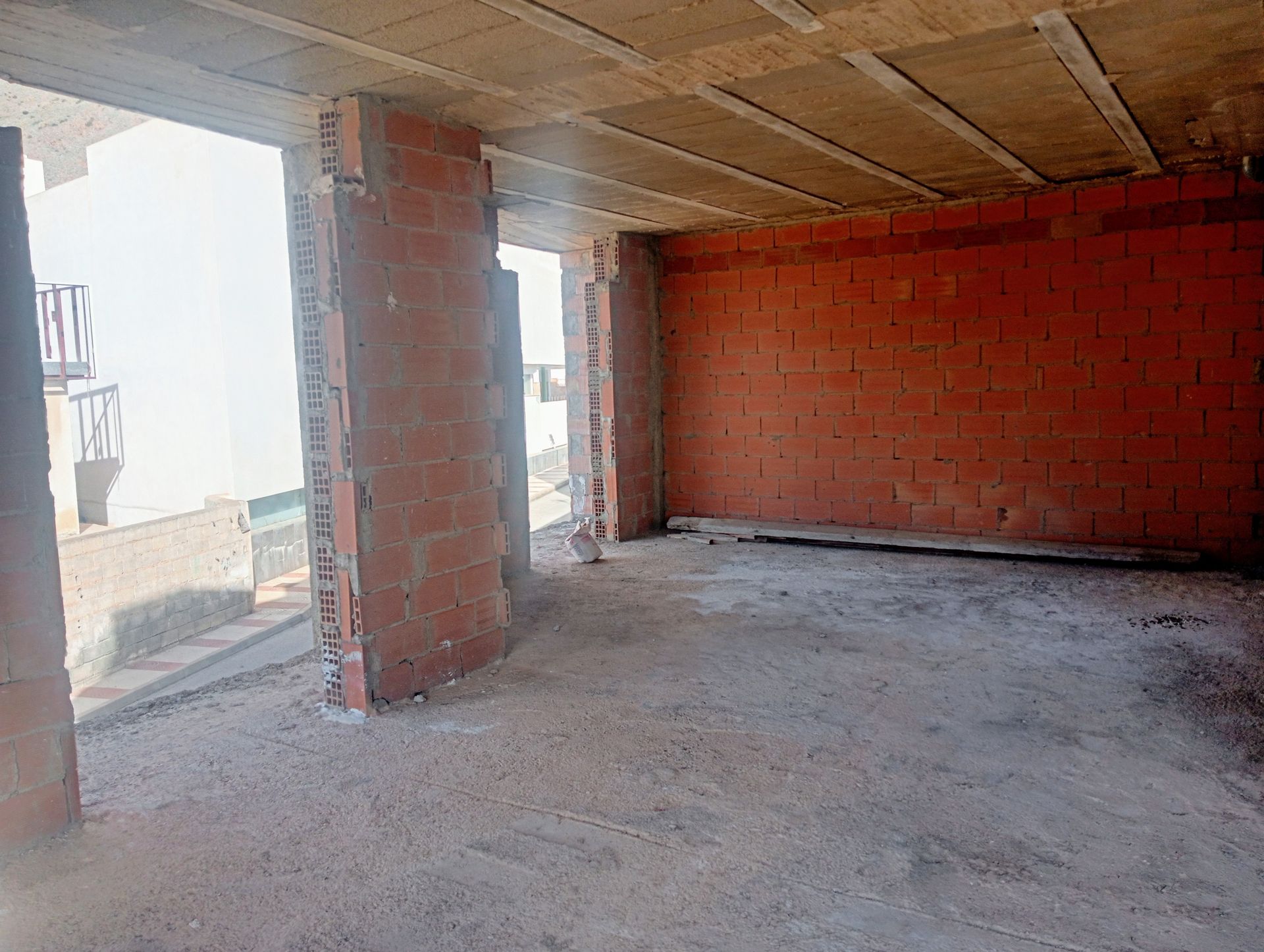 Una habitación vacía con paredes de ladrillo y techo en un edificio en construcción.