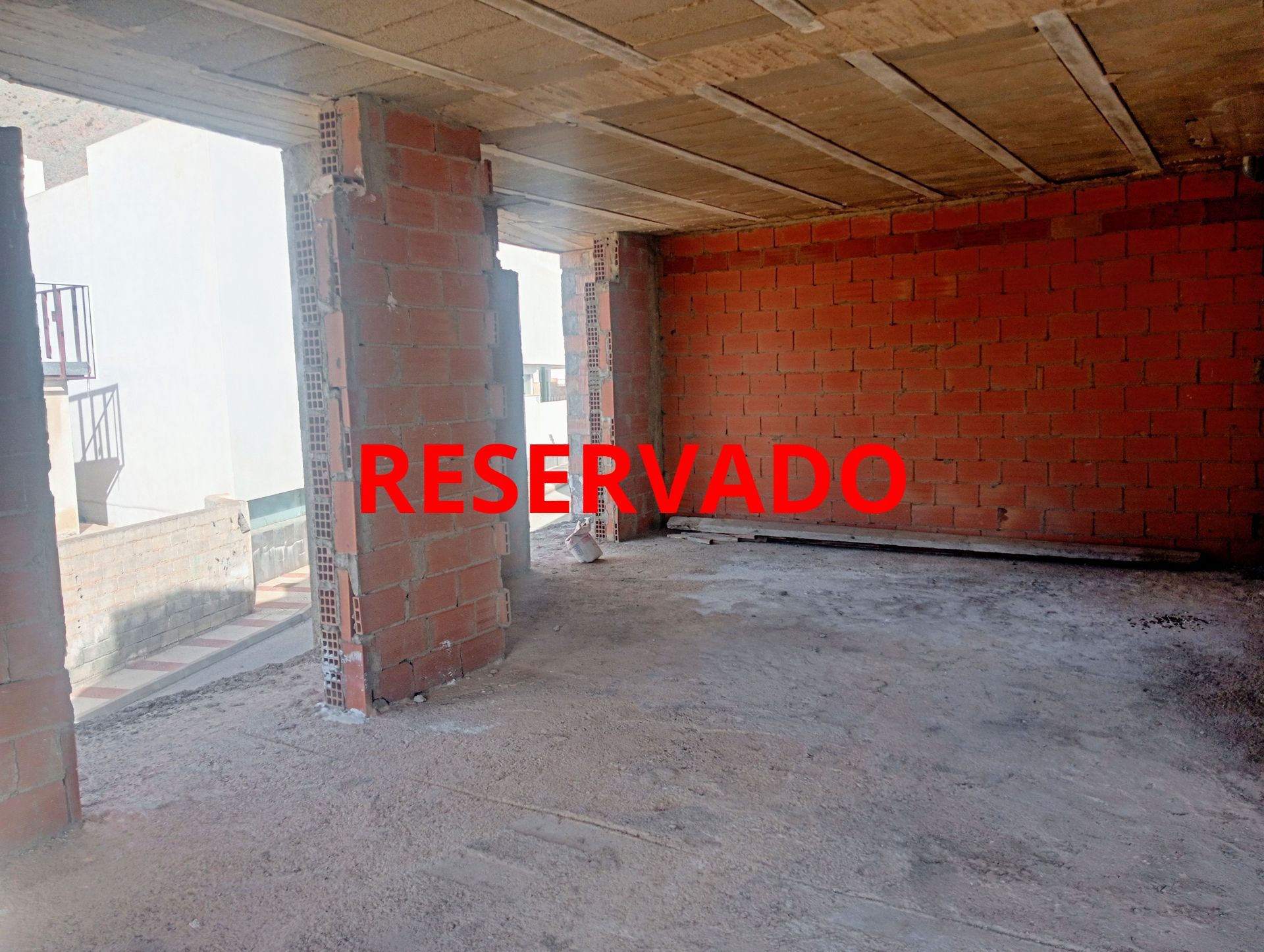 Una habitación vacía con paredes de ladrillo y techo en un edificio en construcción.