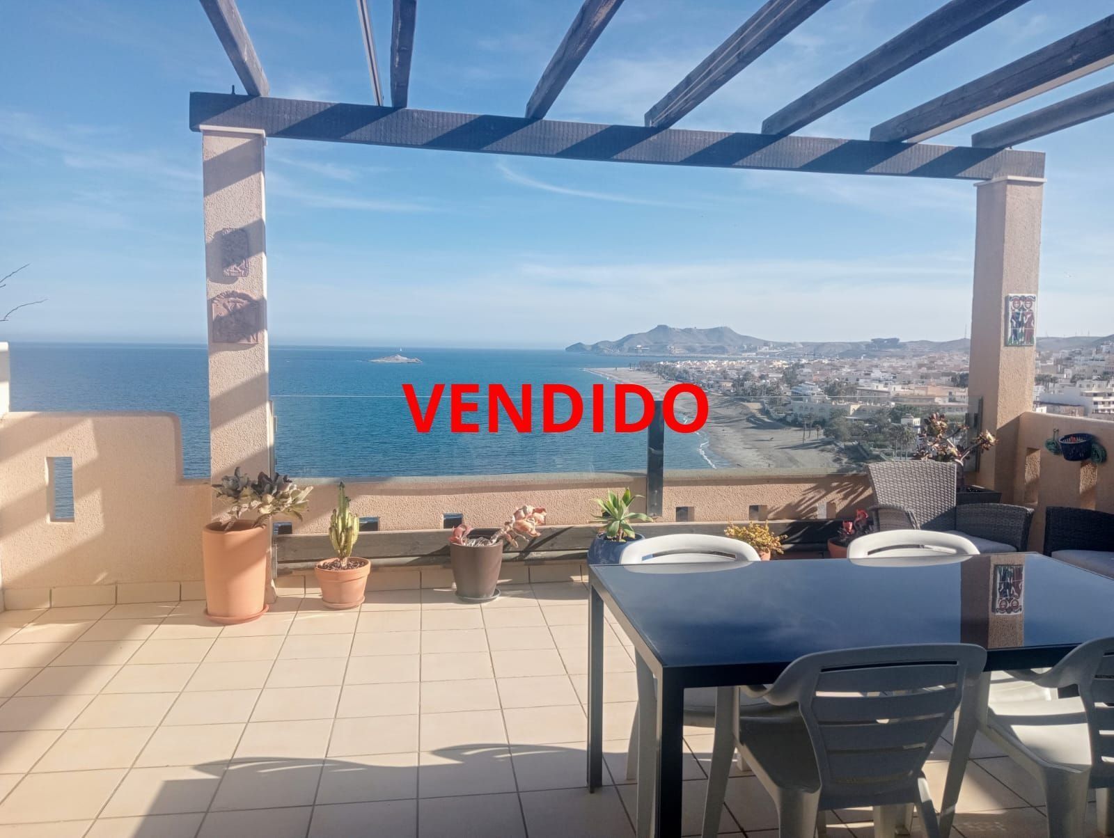 Un patio con mesa y sillas y un cartel que dice vendido