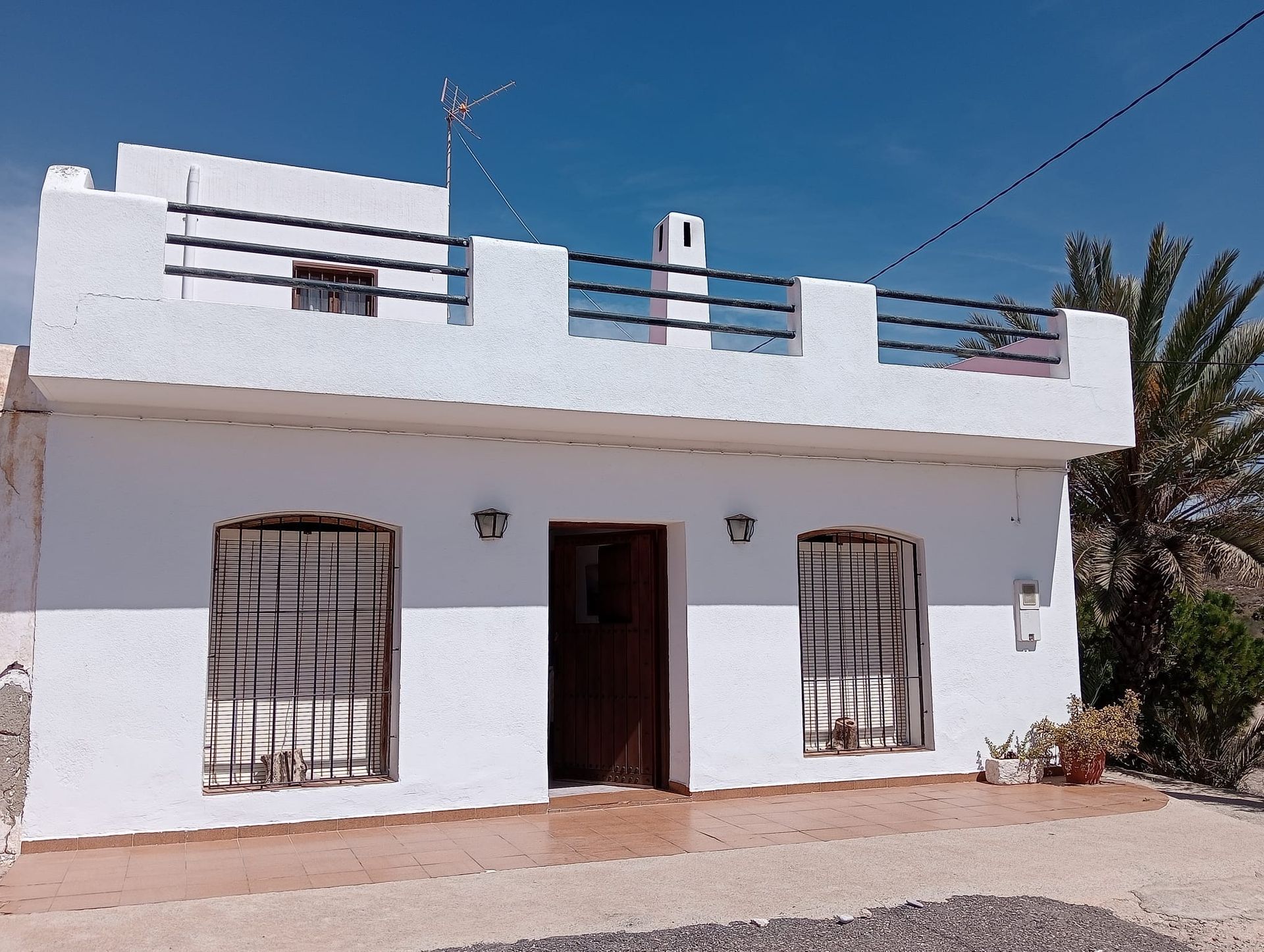 Una casa blanca con una palmera al fondo