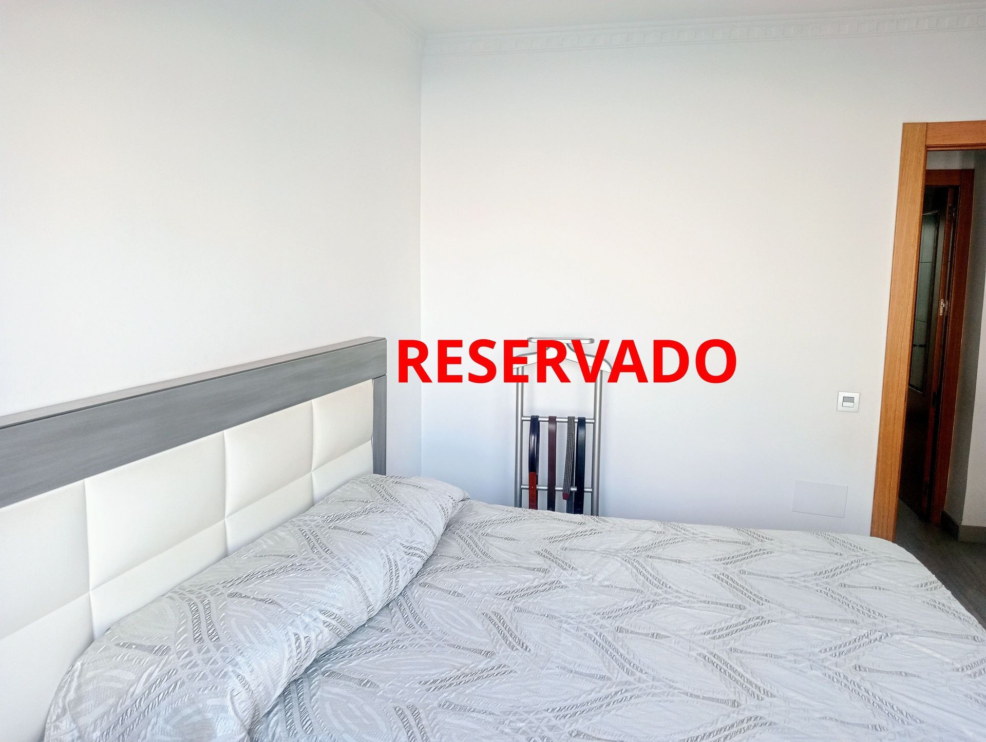 Un dormitorio con una cama y un cartel que dice reservado