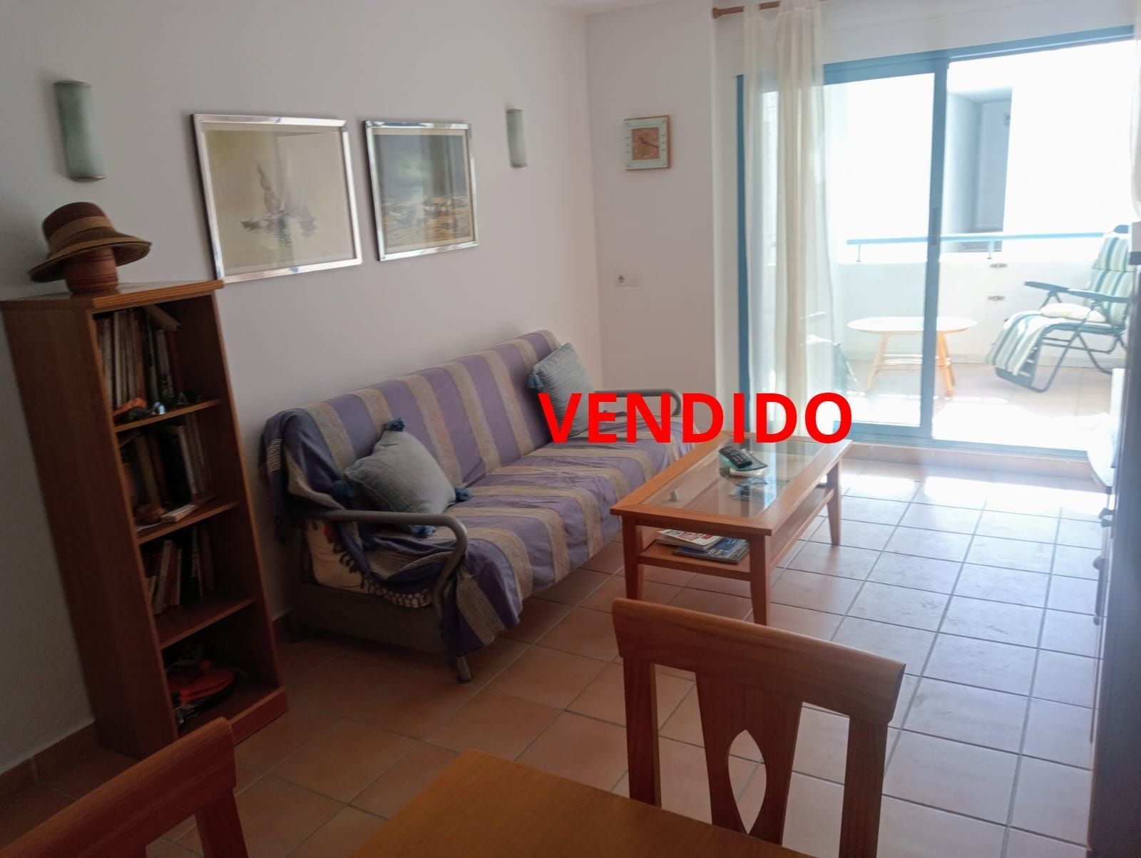 Una sala de estar con un sofá y una mesa que tiene la palabra vendido.