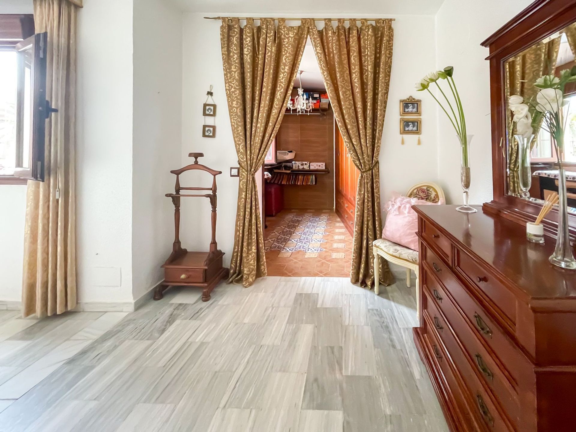 Un largo pasillo con puertas de madera que conducen a diferentes habitaciones de una casa.