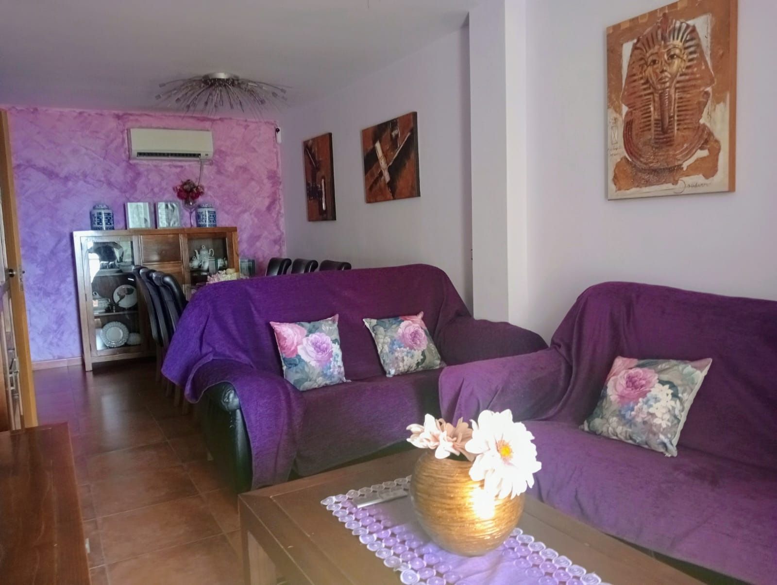 Una sala de estar con muebles morados y un sofá morado.