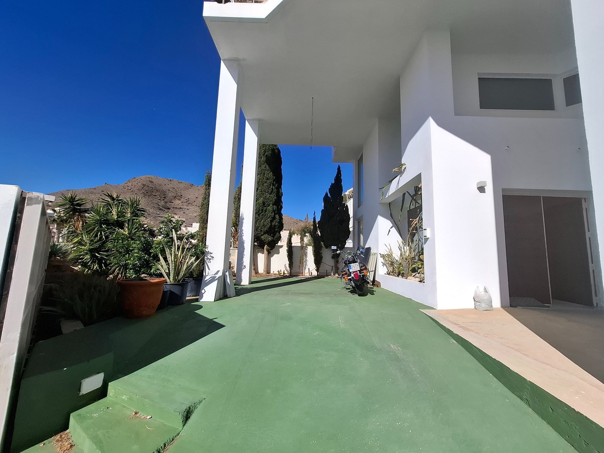 Un edificio blanco con un camino de entrada verde que conduce a él.