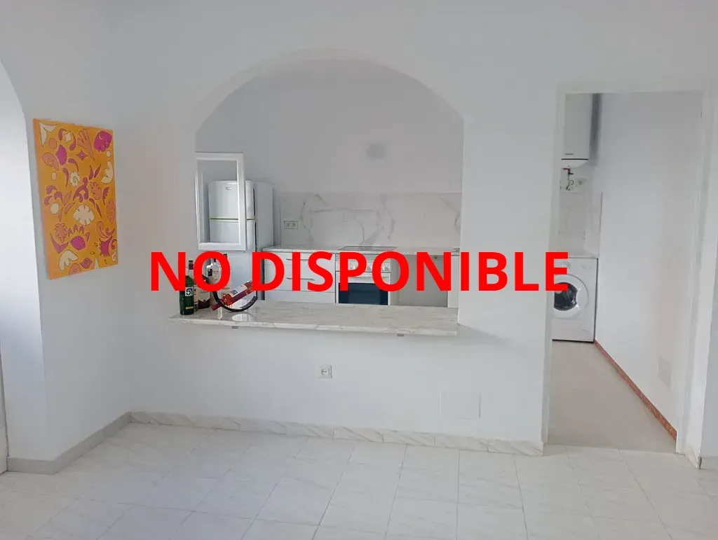 Una cocina con estufa, lavavajillas, microondas y un cuadro en la pared.