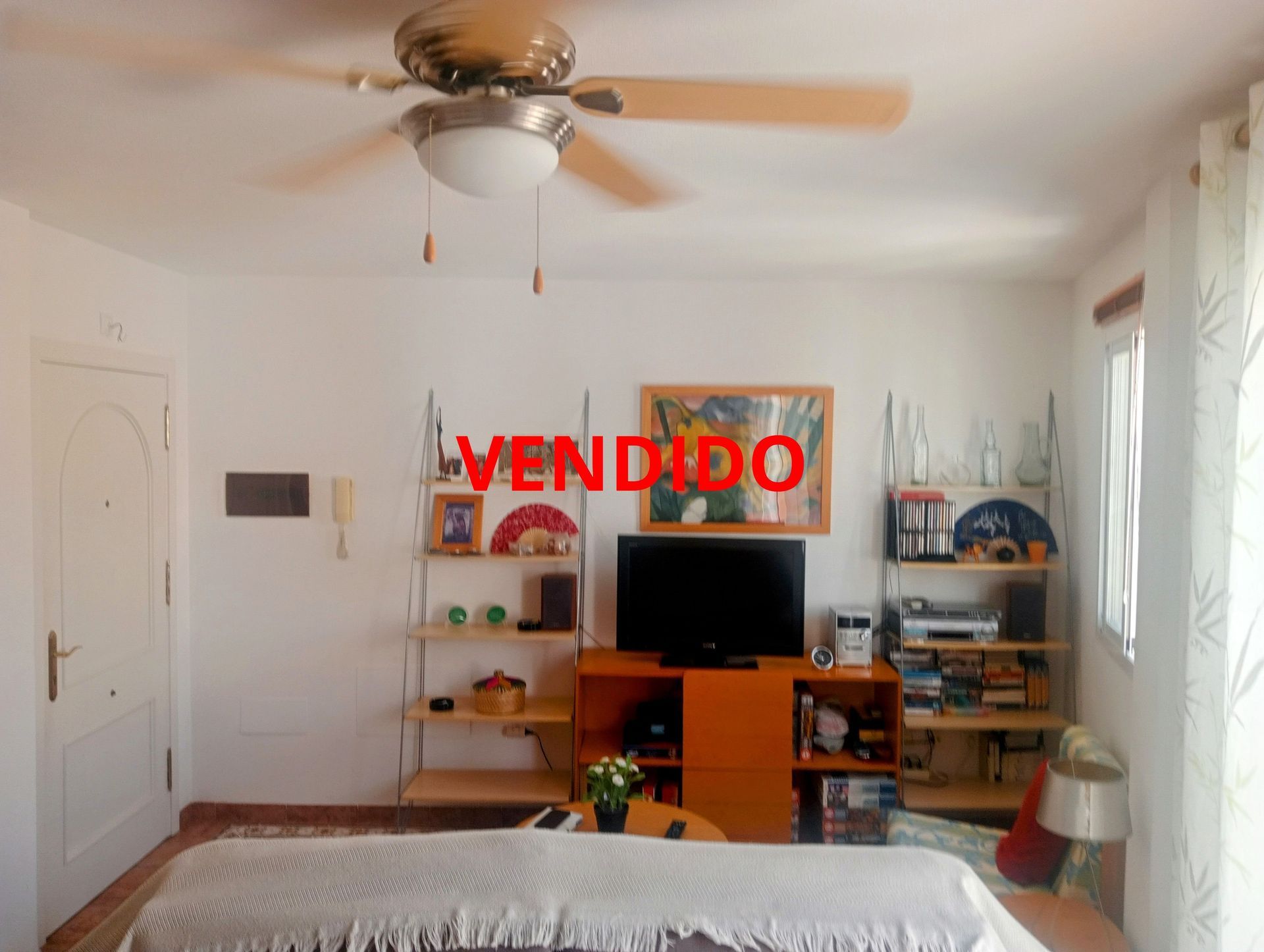 Una sala con un ventilador de techo y un cartel que dice vendido