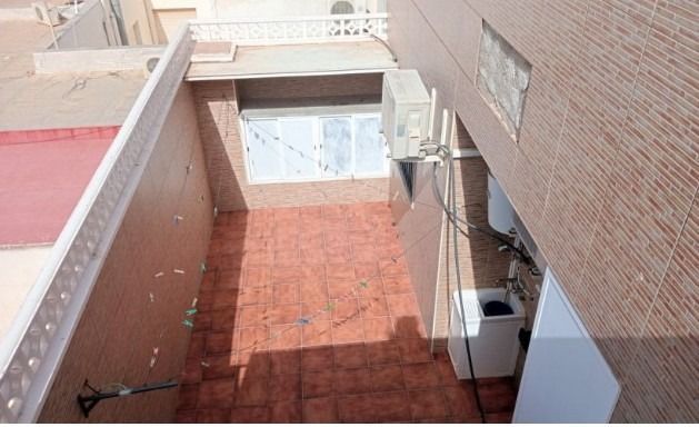 Un pequeño edificio con techo de tejas está en el tejado de un edificio.