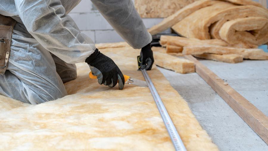 Un artisan qui découpe de la laine de verre