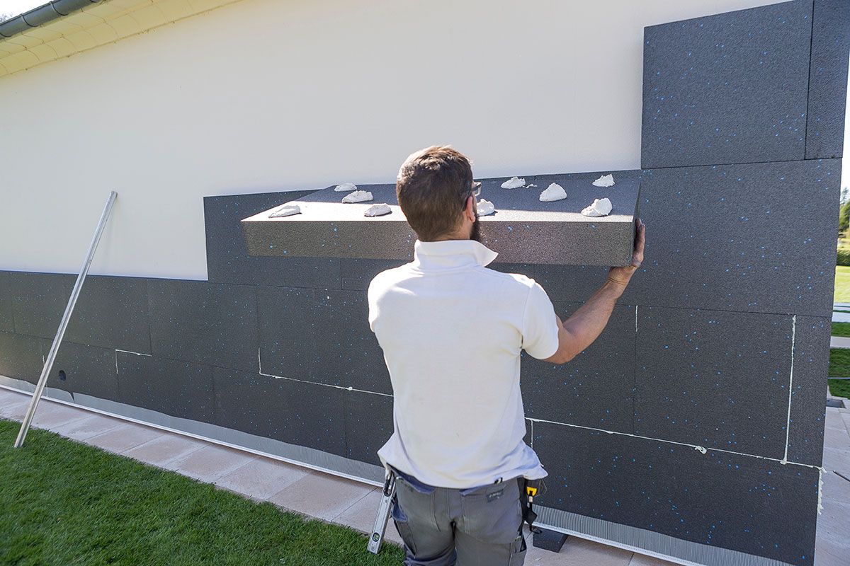 Professionnel en train de poser un isolant extérieur