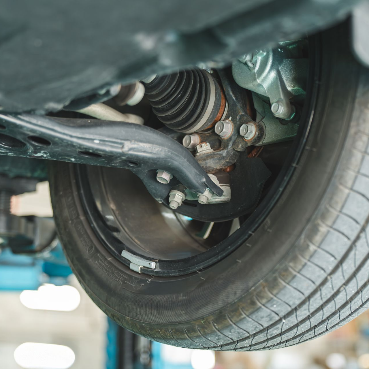 Châssis du véhicule avec les pneus et les éléments de suspension visibles par en dessous.