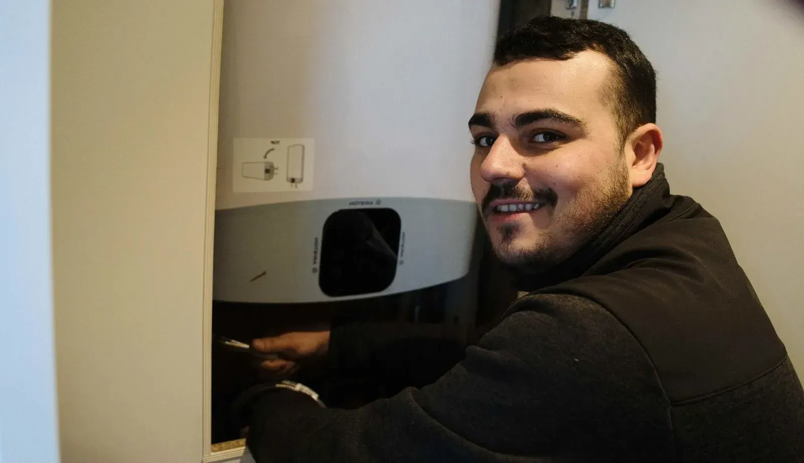 Professionnel réparant un chauffe-eau.