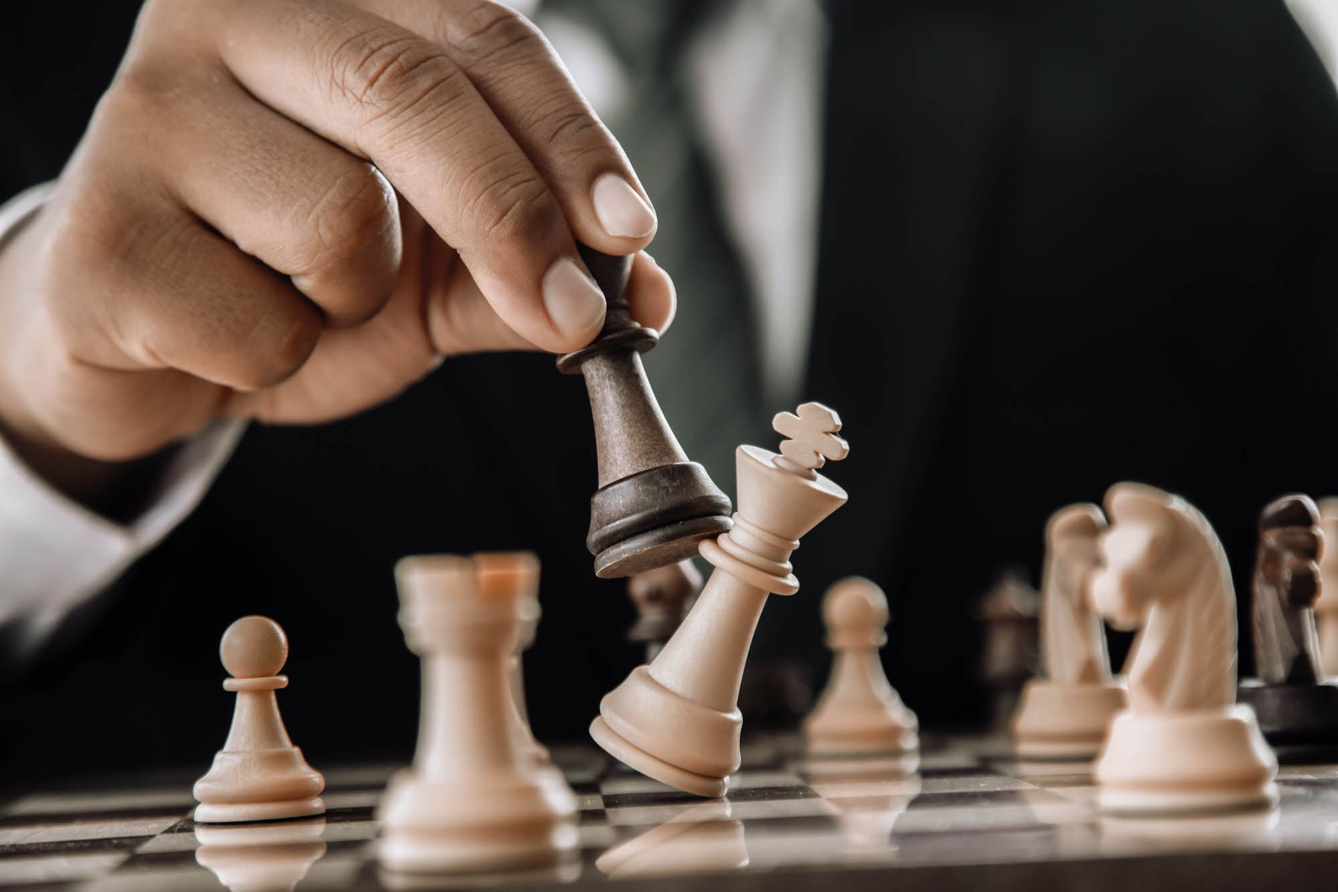 Ein Mann in Anzug und Krawatte spielt eine Partie Schach.
