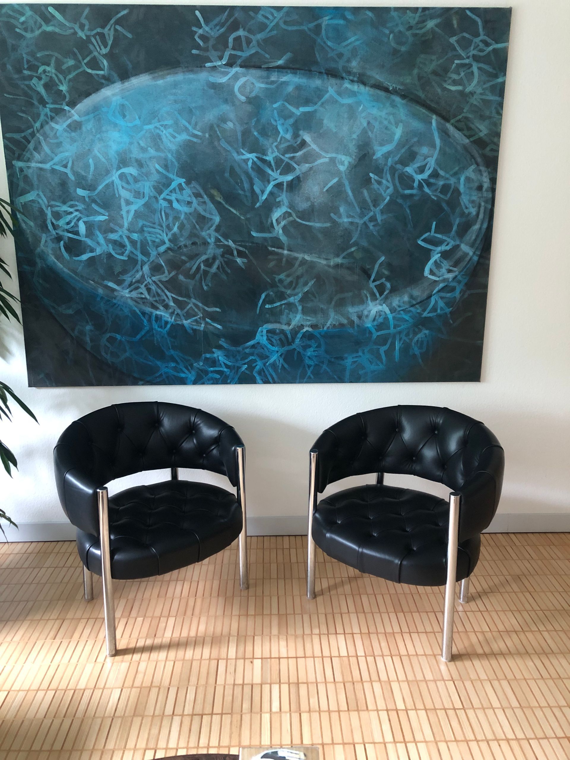 Zwei schwarze Stühle vor einem Gemälde an der Wand
