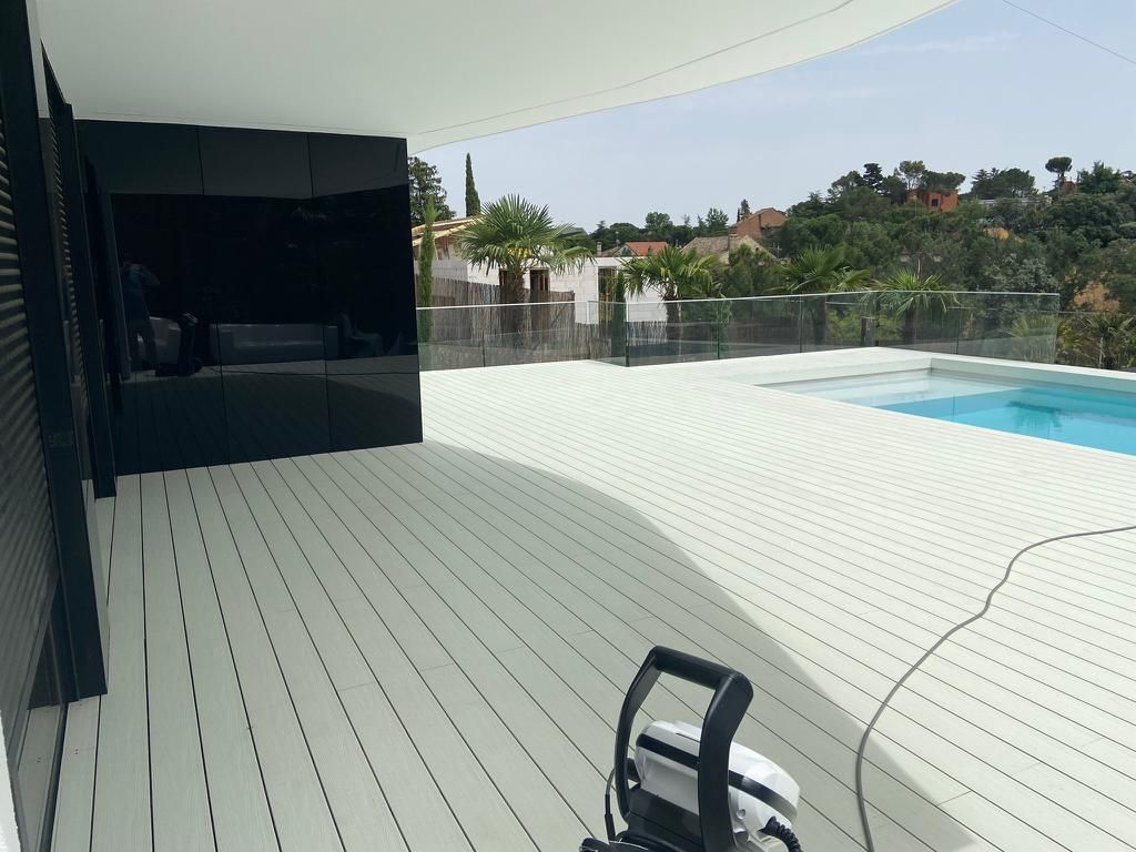 Un patio con una mesa y sillas bajo una pérgola.