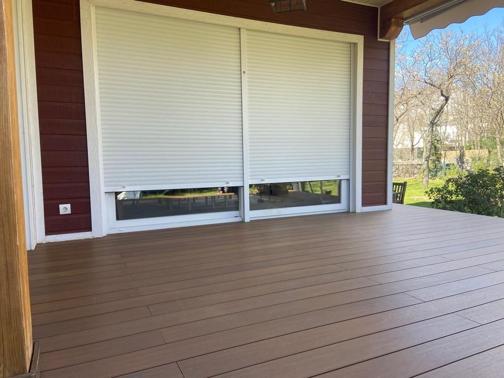 Una vista aérea de un patio con mesas y sillas bajo una pérgola.