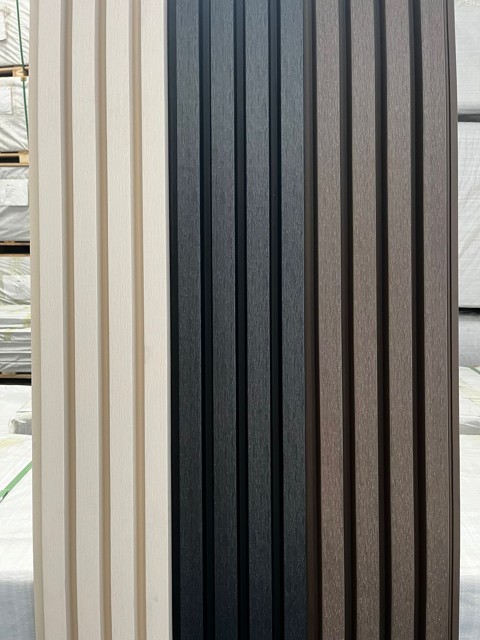 Tres paneles corrugados verticales en color crema, carbón y marrón.