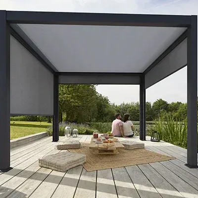 Una pareja está sentada bajo una pérgola en una terraza de madera.