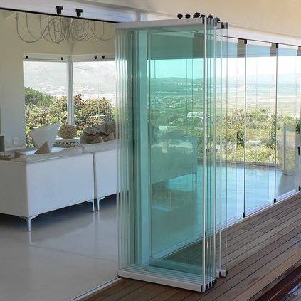 Una sala de estar con muchas ventanas y una puerta corrediza de vidrio.