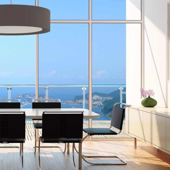 Un comedor con mesa y sillas con vista al mar.