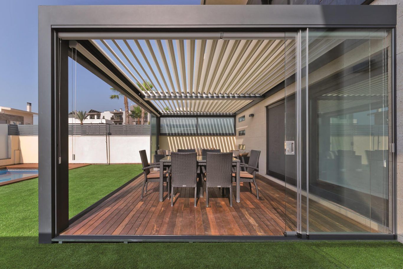 Un patio con una mesa y sillas bajo una pérgola.