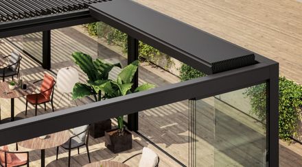 Una vista aérea de un patio con mesas y sillas bajo una pérgola.