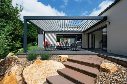 Una casa con una pérgola y escaleras que conducen a ella.
