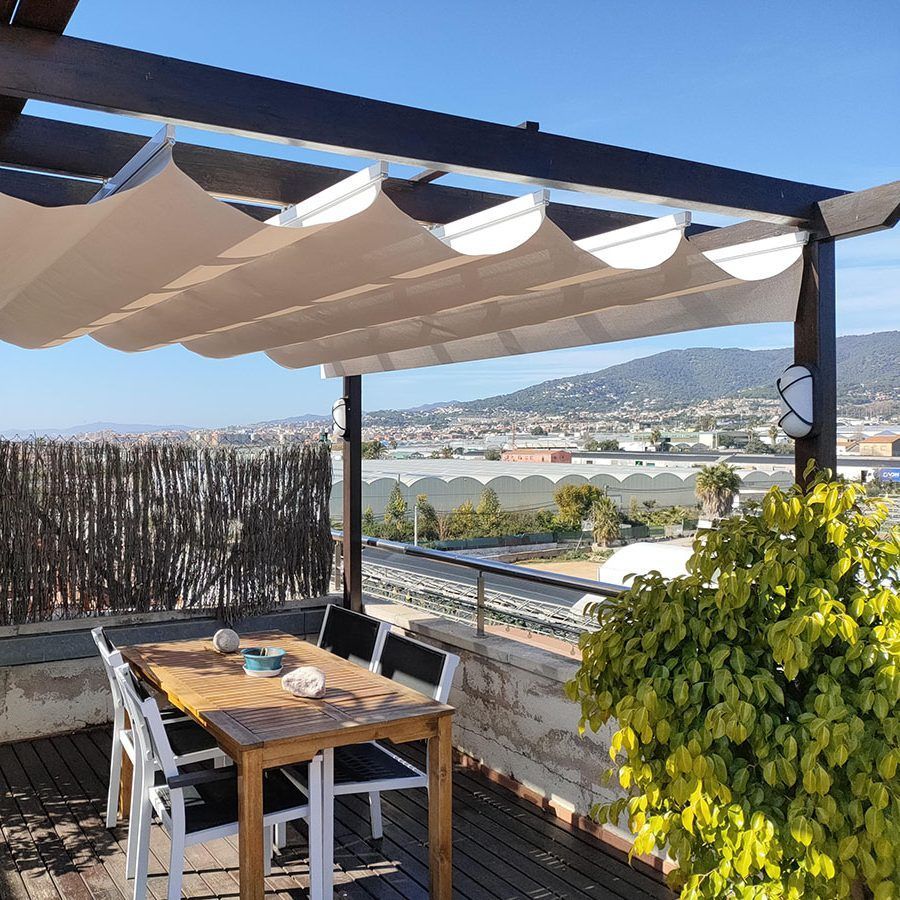 Un patio con una mesa y sillas bajo un dosel.