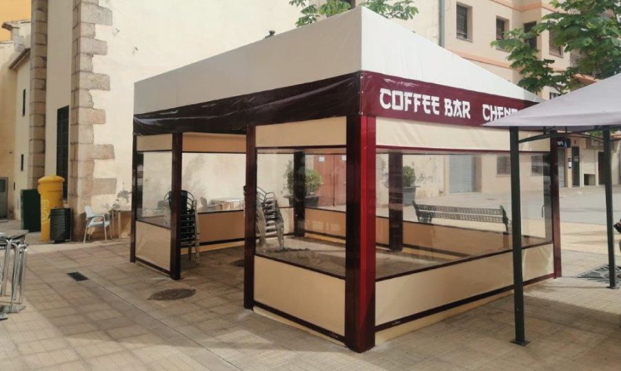 Cafetería al aire libre con paredes color canela, ventanas transparentes, detalles en color burdeos y techo blanco.