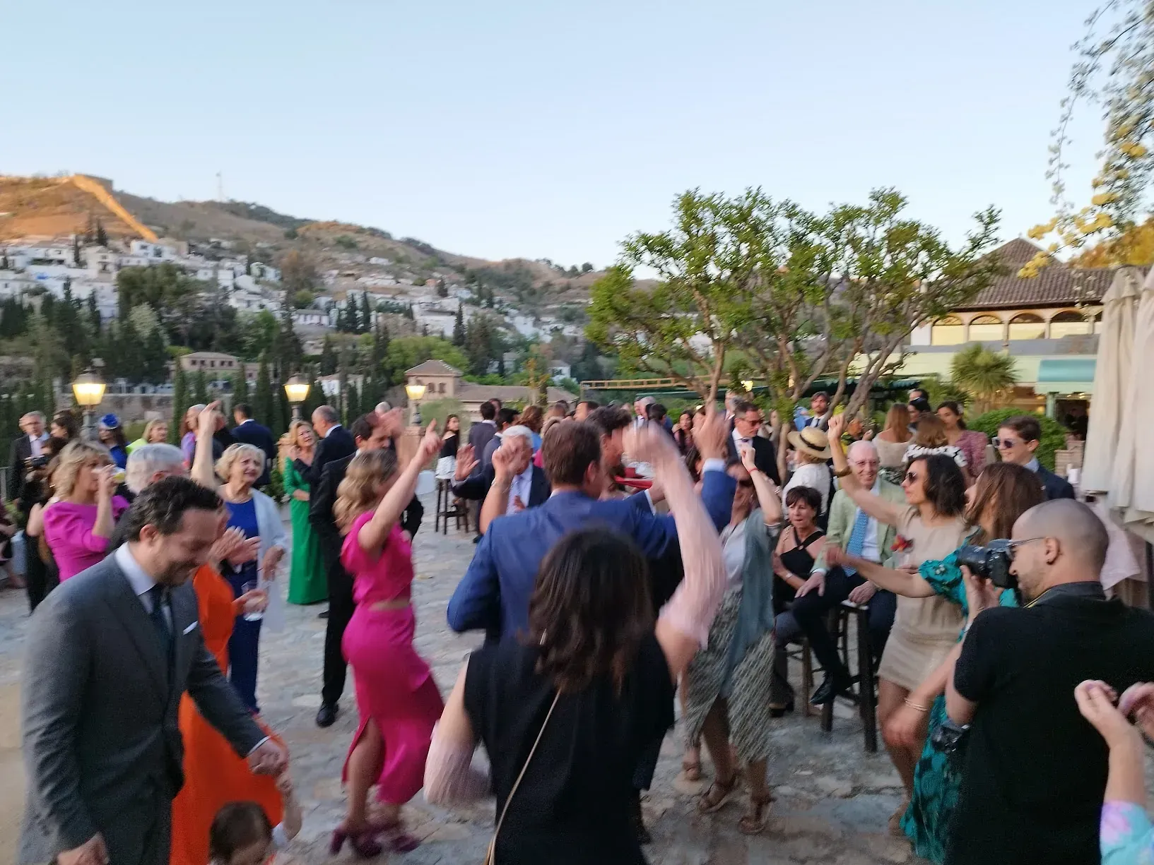 Un grupo grande de personas está bailando en una recepción de boda.