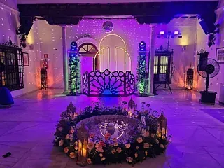 Una habitación grande con luces violetas y flores en el suelo.
