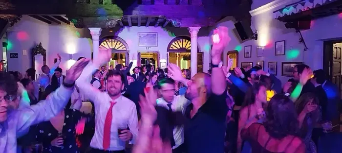 Un grupo grande de personas está bailando en una fiesta.