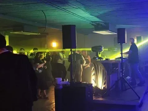 Un grupo de personas está bailando en una habitación oscura en una fiesta.