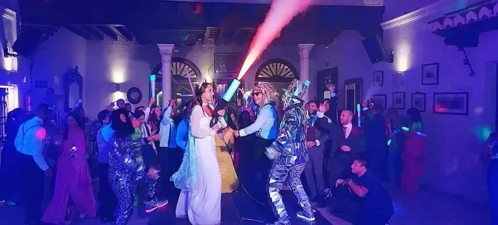 Una novia y un novio están bailando frente a una multitud en una recepción de boda.