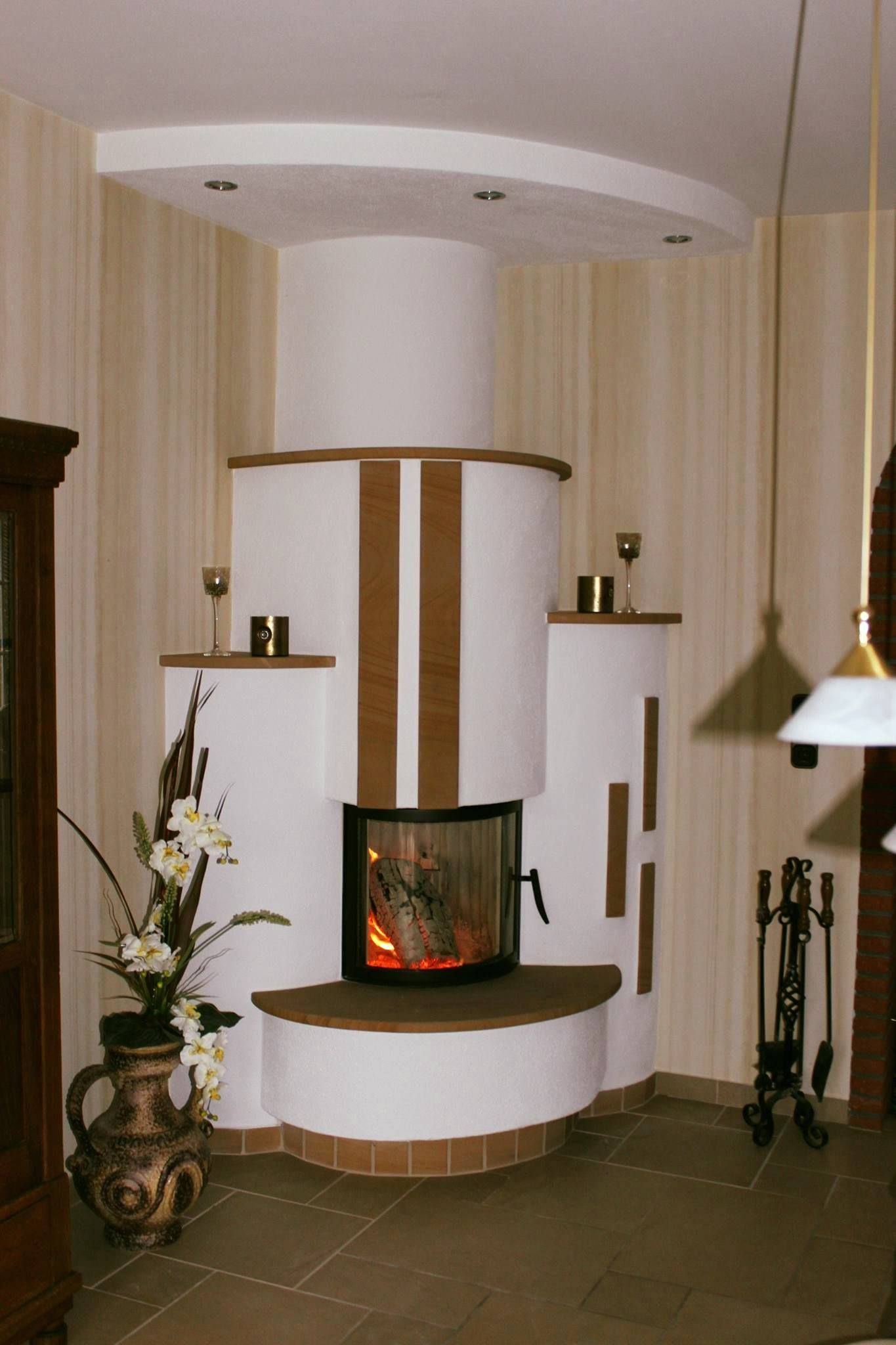 Ein Wohnzimmer mit Kamin und einer Vase mit Blumen