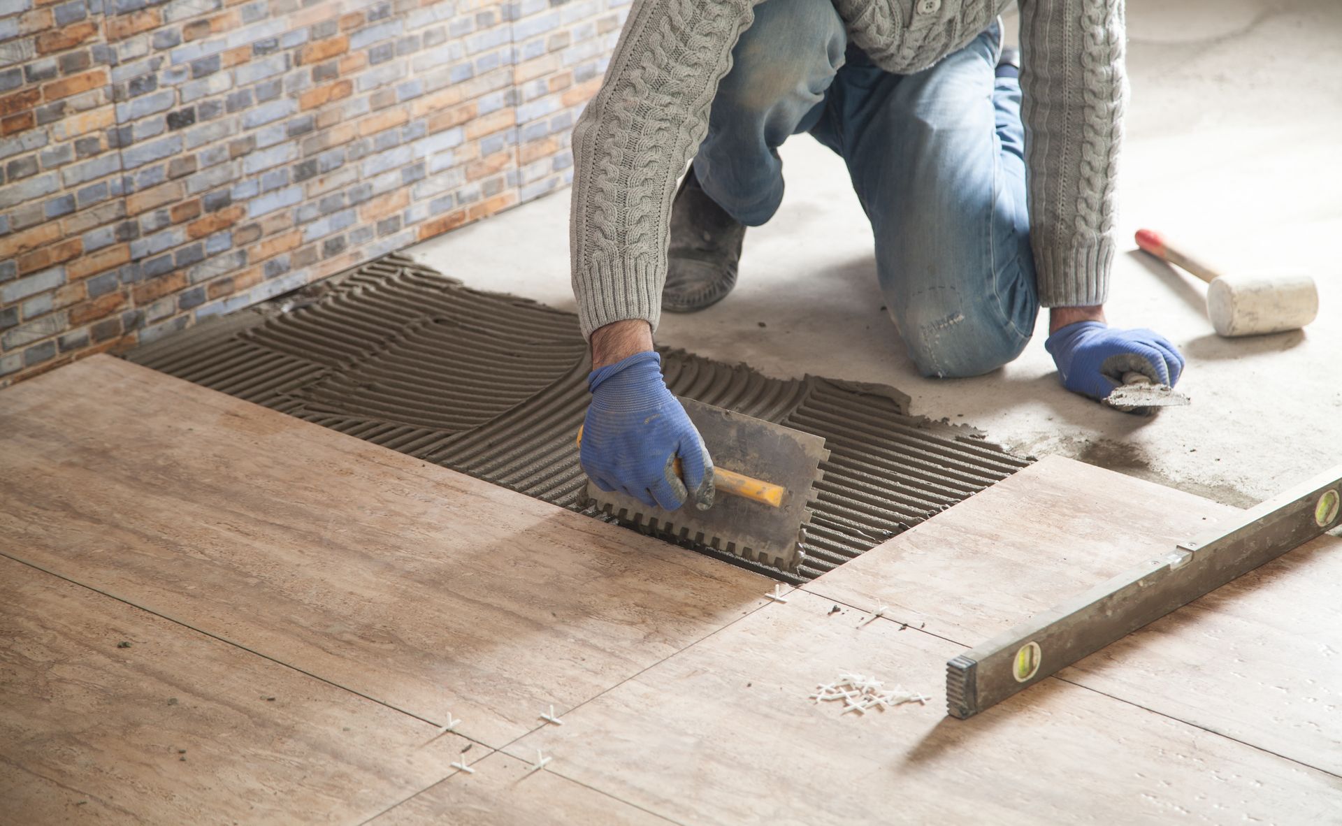 Une personne applique de la colle à carrelage