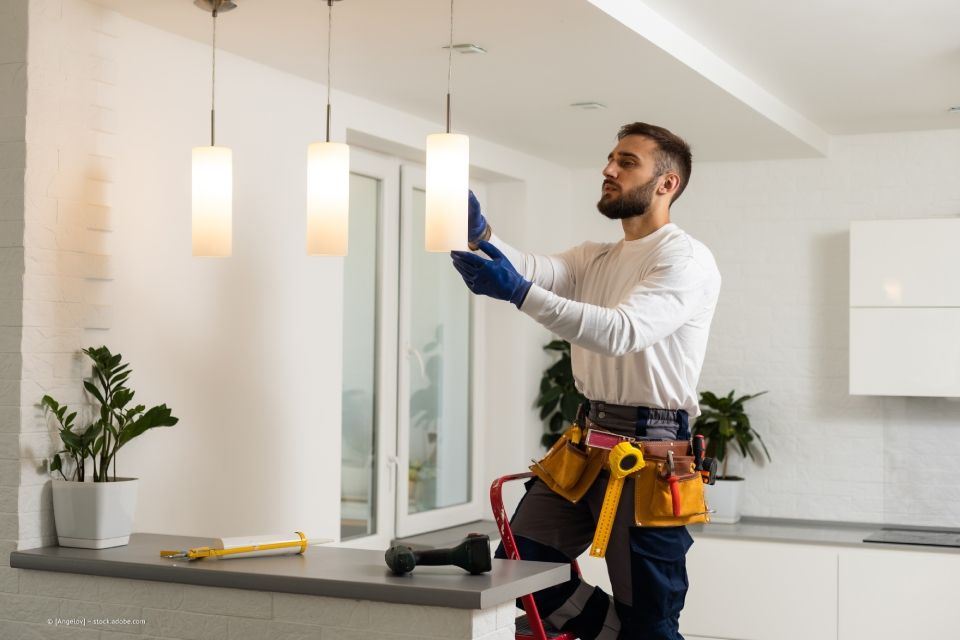 Lampeninstallation in einer Küche durch männlichen Elektriker