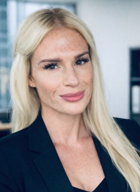 Mann mit kurzen Haaren und hellen Augen lächelt, er trägt ein weißes Hemd; Innenraum.