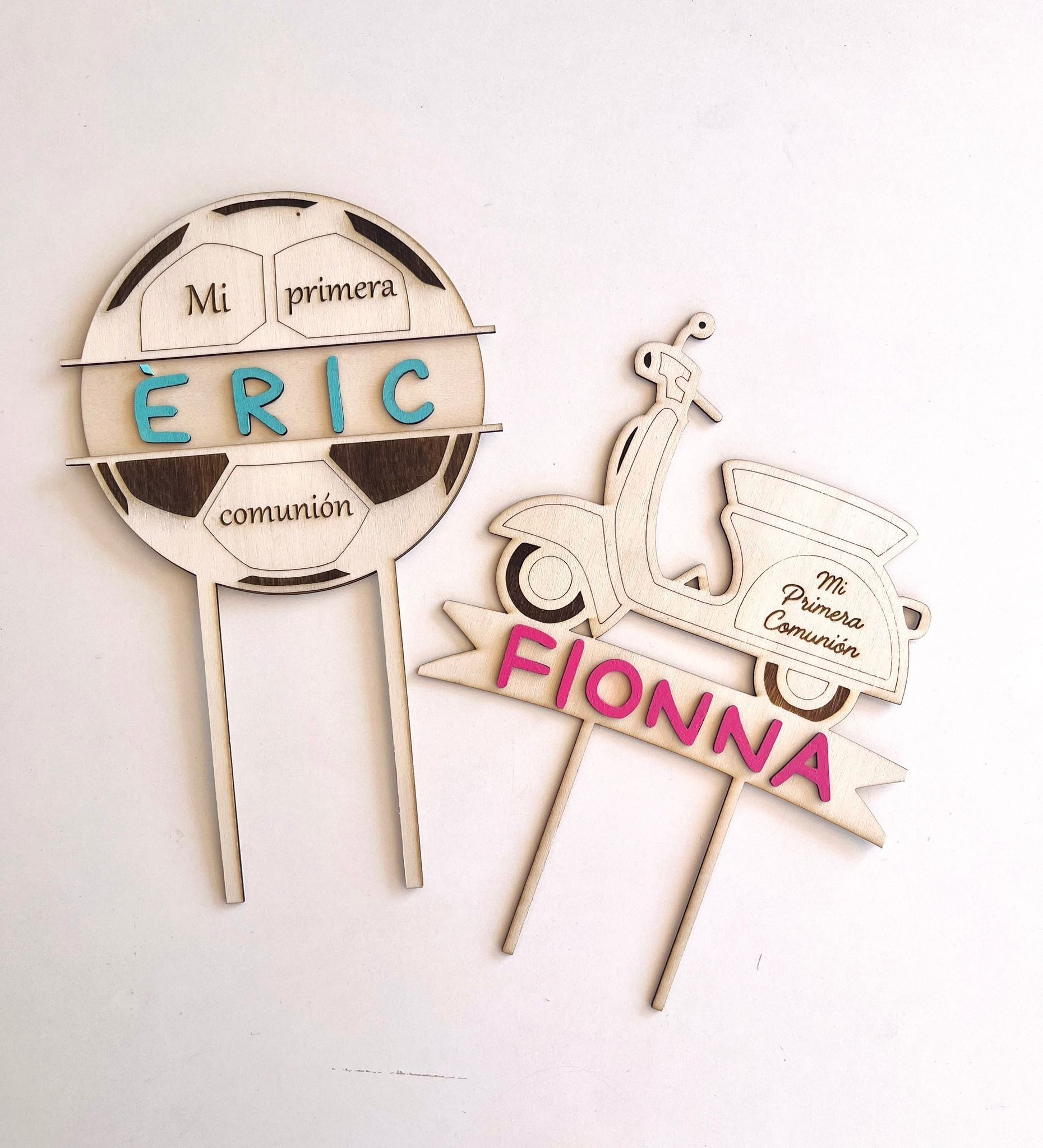 Dos adornos de madera cortados con láser para tartas: uno con forma de balón de fútbol con la palabra 