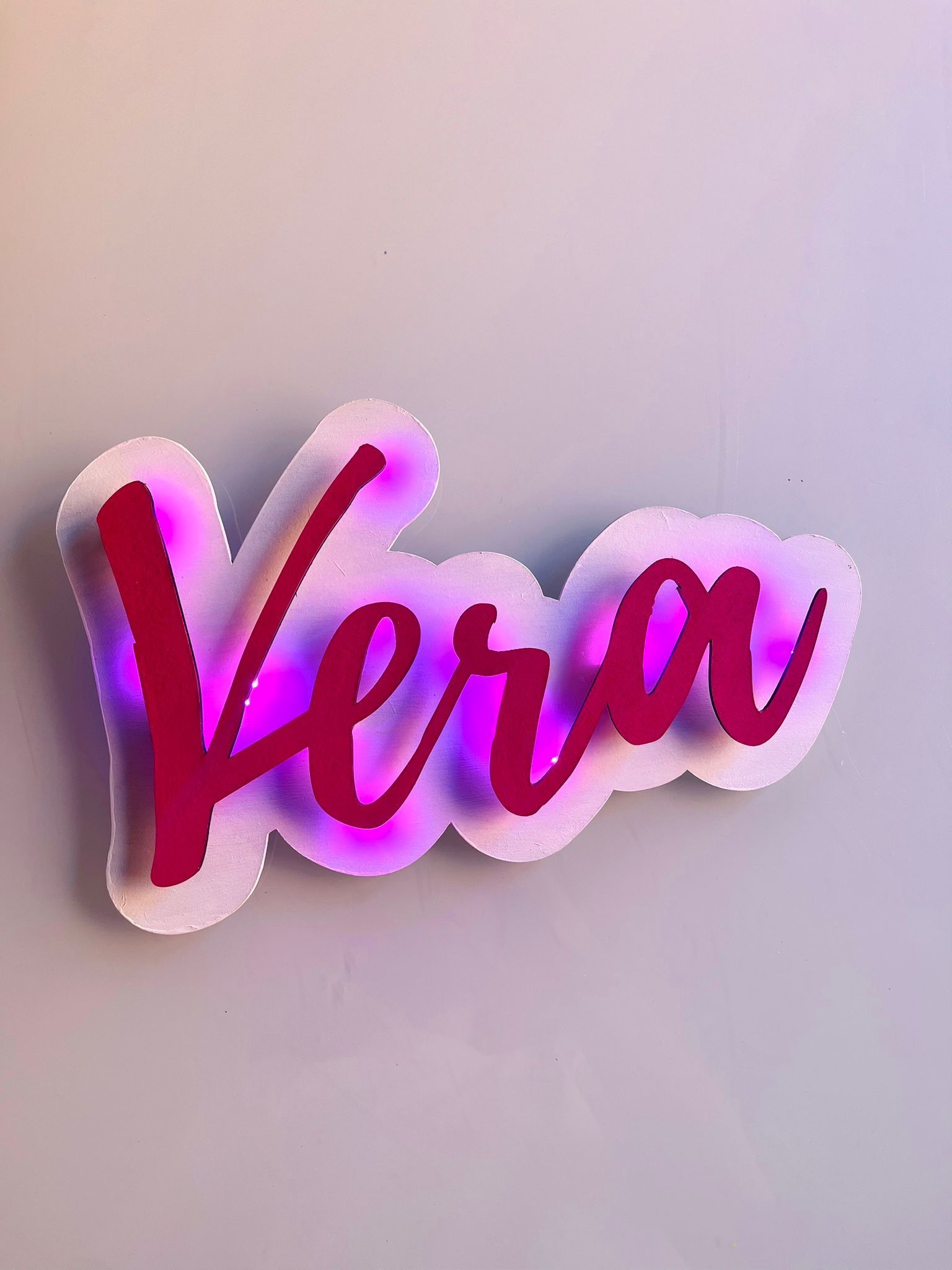 Un letrero de neón rosa con la palabra 